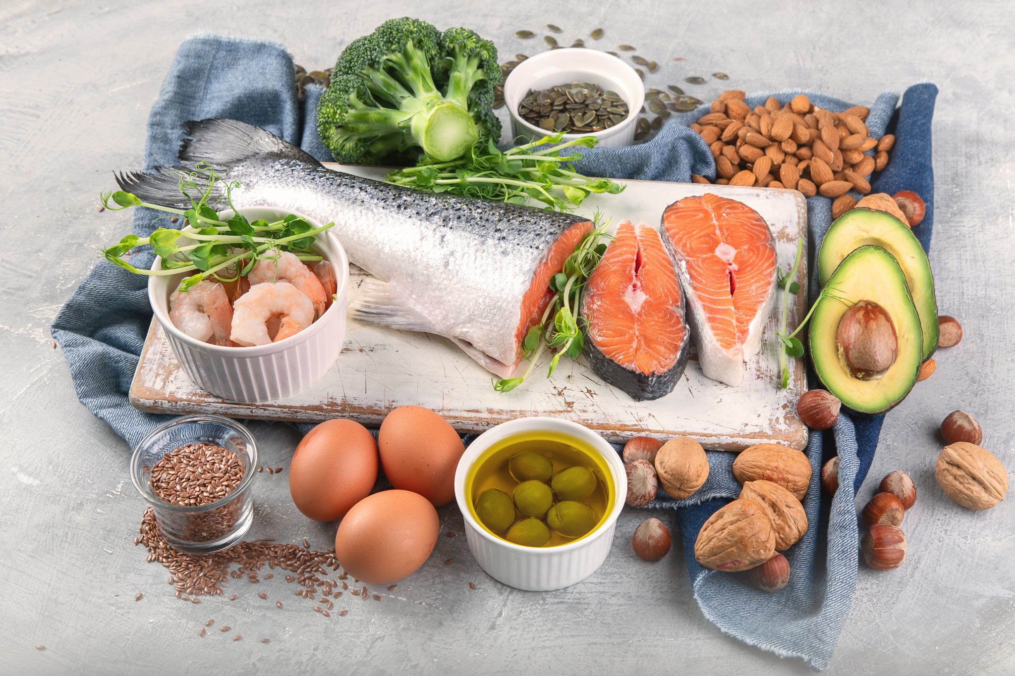 Alimentation et acné : quels aliments choisir contre l'acné 4 Panier garni d'aliments anti-acné avec du saumon, des légumes et des oeufs