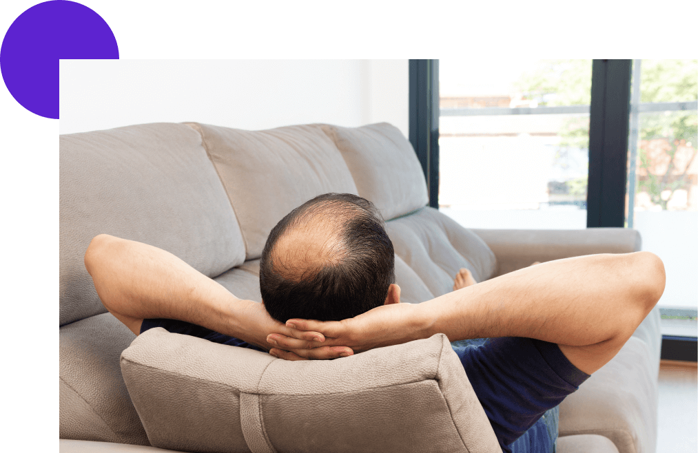 alopécie homme assis dans un canapé et vue de dos