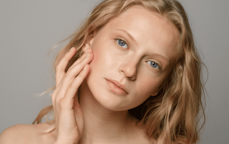 Alimentation et acné : quels aliments choisir contre l'acné 7 femme blonde qui se touche la peau